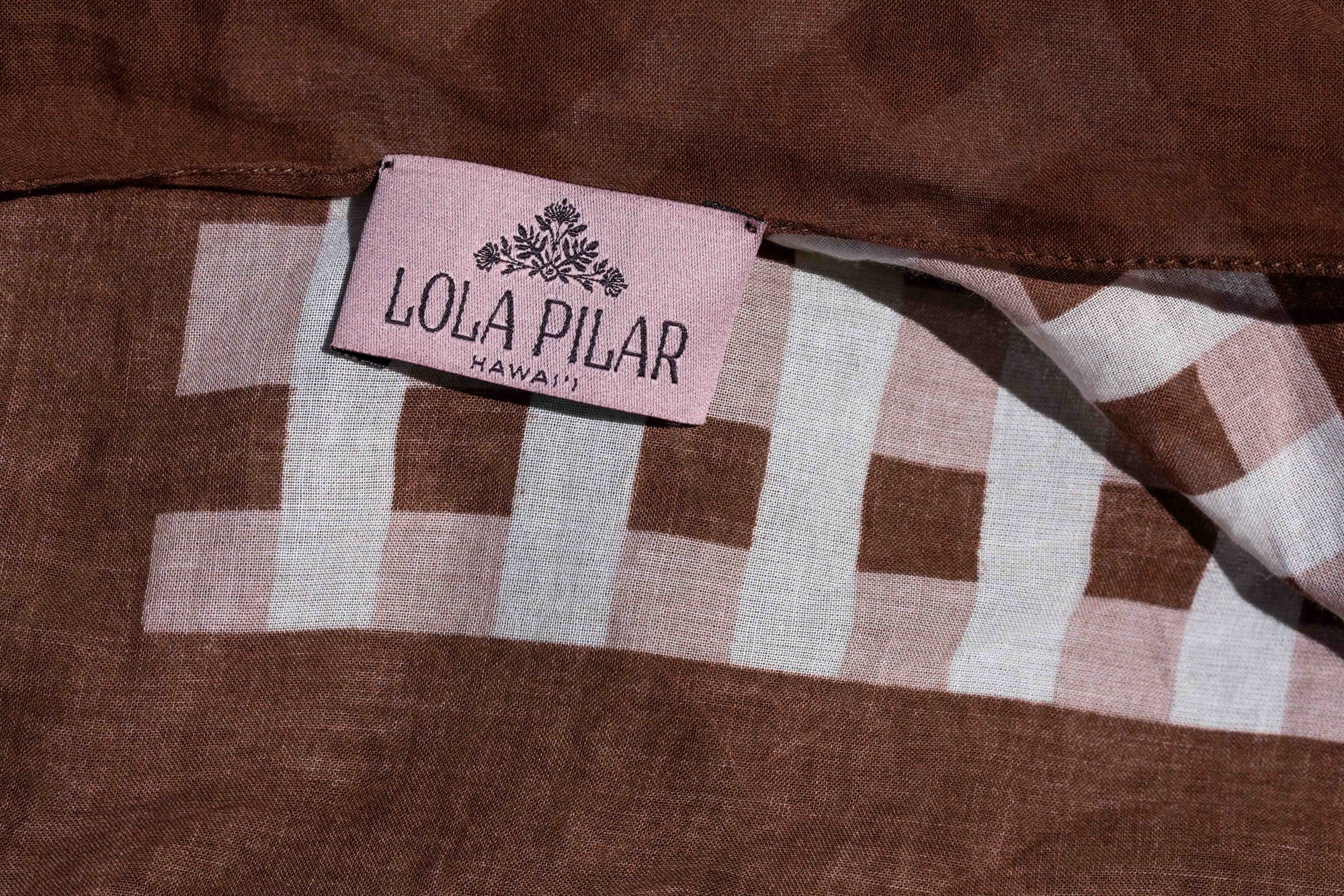 close up Lola Pilar hangtag designed in hawaii made in italy sarong beach coverup
