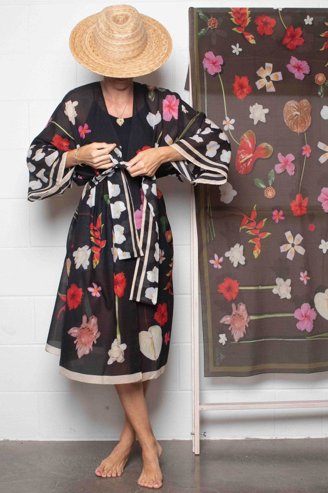 Lola Pilar cotton kimono robe with elegant black background and lush Hawaiian floral print featuring hibiscus, heliconia, torch ginger, plumeria, and banana flowers, made in Italy and designed in Hawaii.