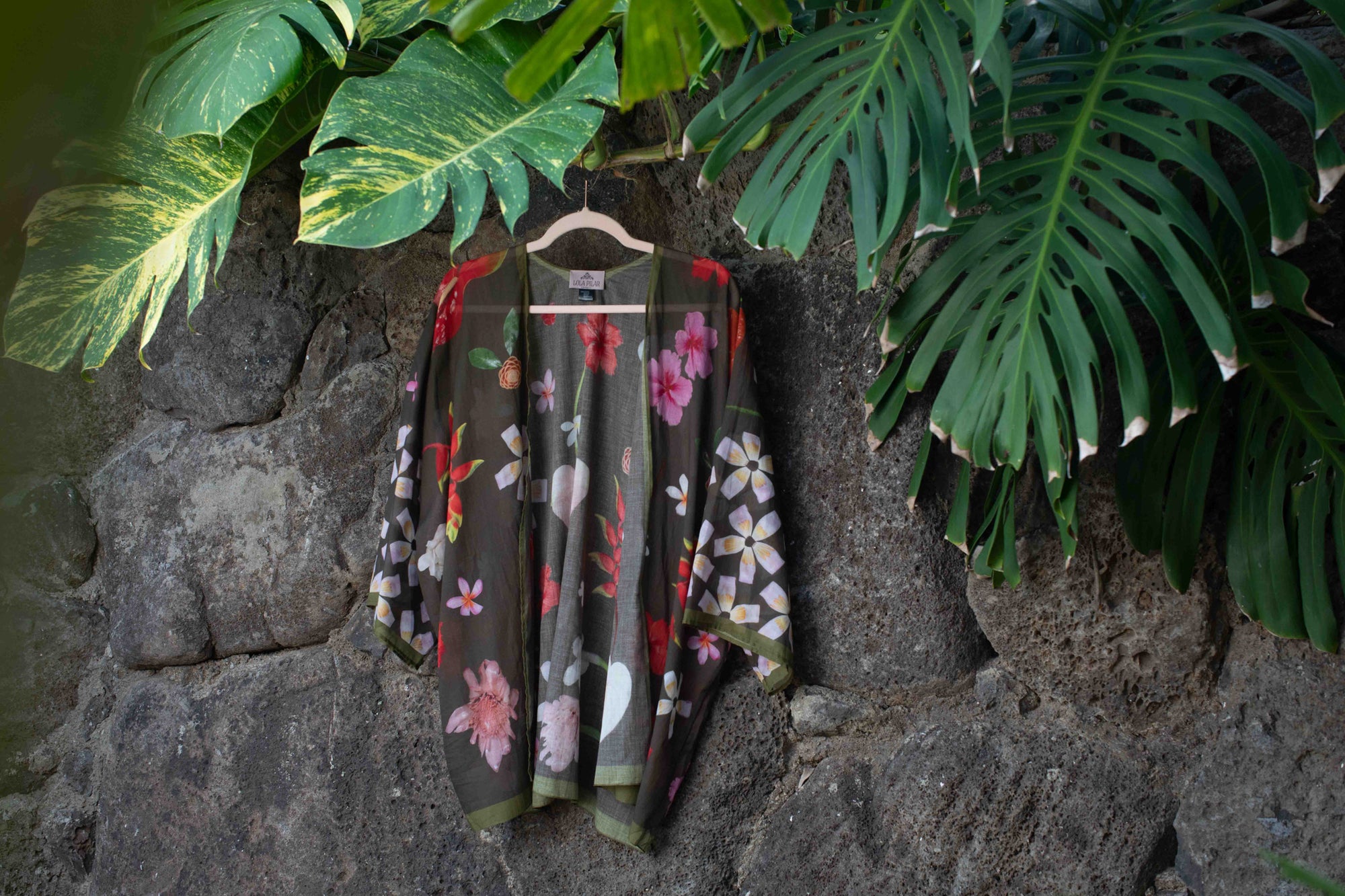 Chic Hawaii-designed cotton kimono top with moss green backdrop and vibrant hibiscus, torch ginger, and plumeria artwork.