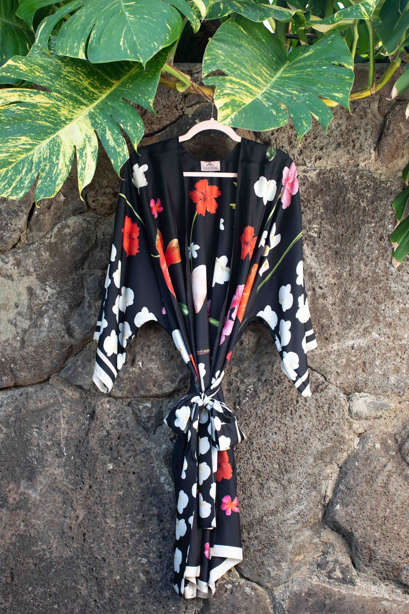 Designer black silk floral robe featuring hibiscus, plumeria, torch ginger, and hanging heliconia inspired by timeless Hawaii glamour.