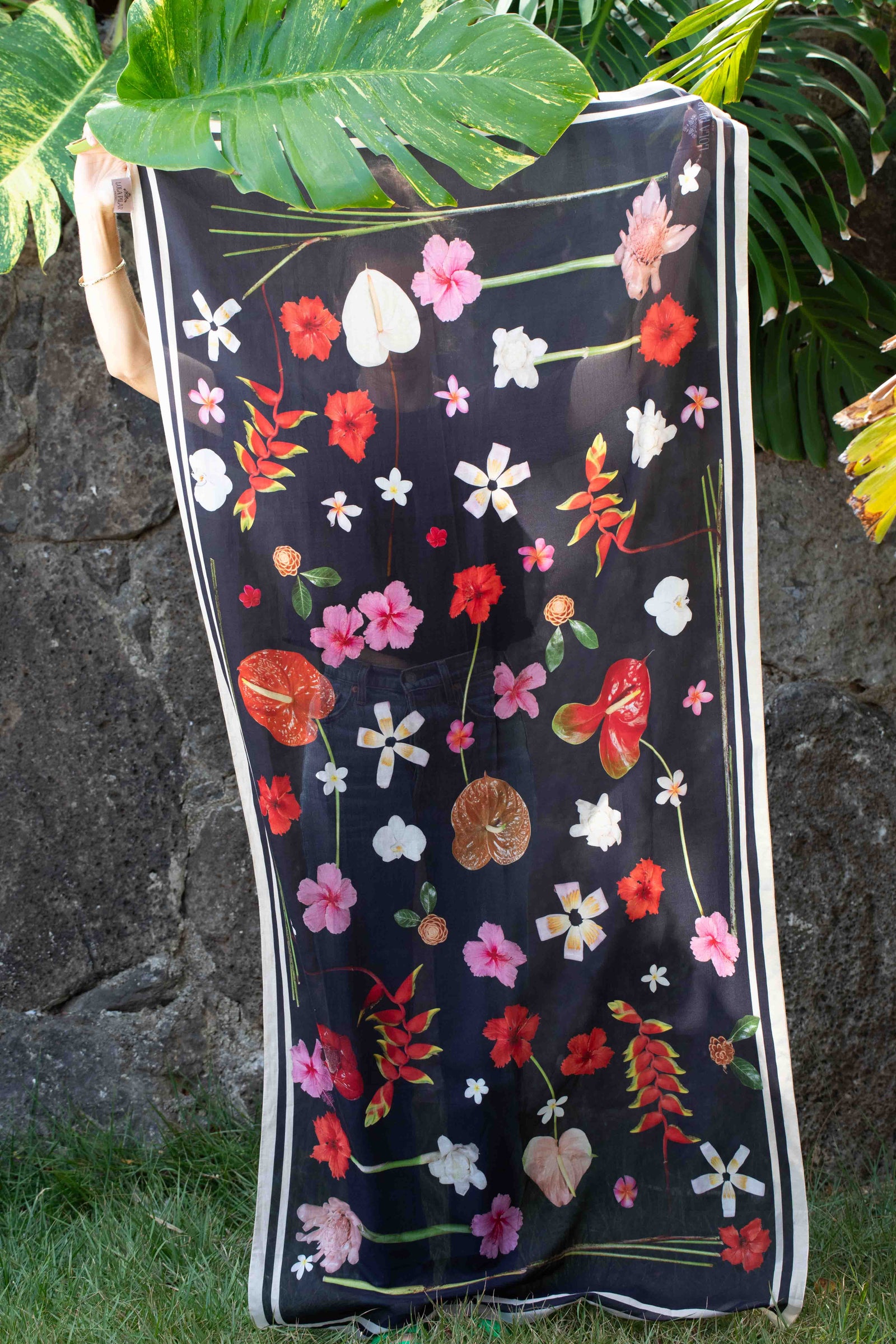 Lola Pilar tropical sarong with black background featuring hibiscus, torch ginger, hanging heliconia, plumeria, and banana flowers in pink, yellow, red, and white, made in Italy and designed in Hawaii.