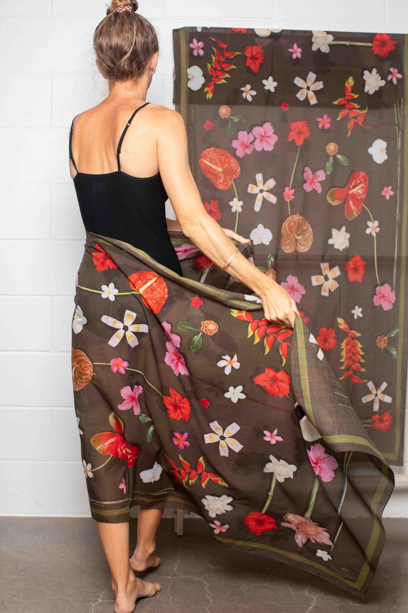 Moss green floral pareo by Lola Pilar with vibrant Hawaiian hibiscus, heliconia, torch ginger, plumeria, and banana blossom artwork, made in Italy and designed in Hawaii.