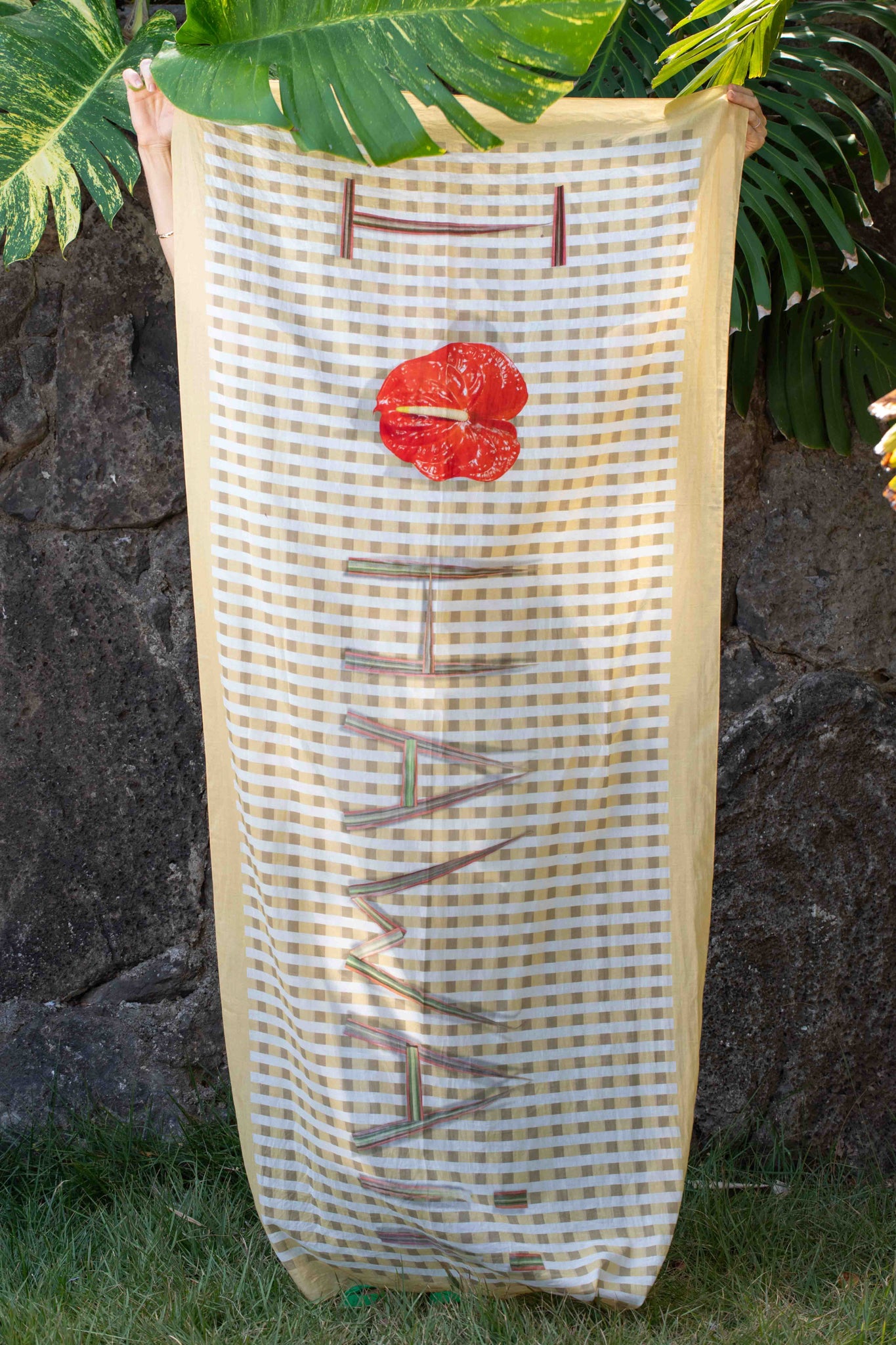 Hawaiian-inspired travel scarf with yellow and white check palaka pattern and “I Love Hawaii” design accented by a red anthurium. Lola Pilar
