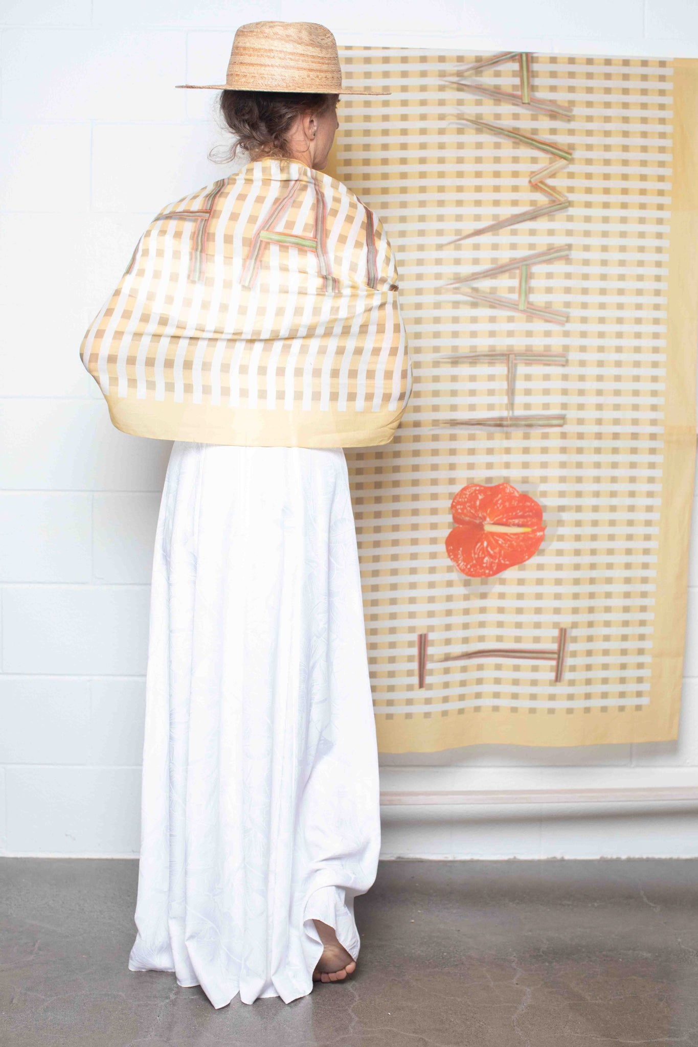 Italian-made sarong designed in Hawaii with yellow and white checkered print, “I Love Hawaii” lettering, and red anthurium accent Lola Pilar