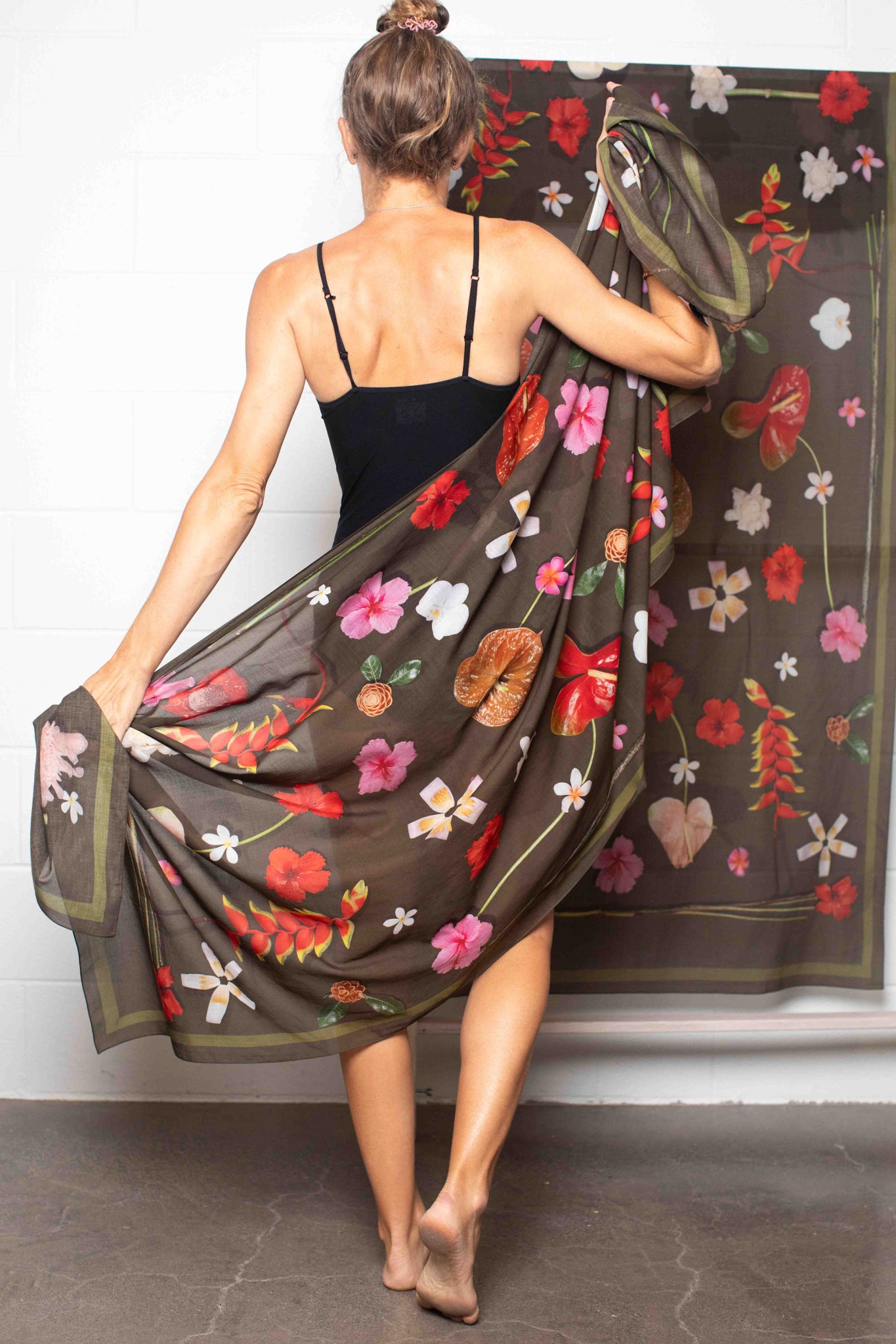 Lightweight floral shawl with moss green backdrop and tropical flowers including hibiscus, plumeria, torch ginger, and heliconia in vivid island colors by Lola Pilar.