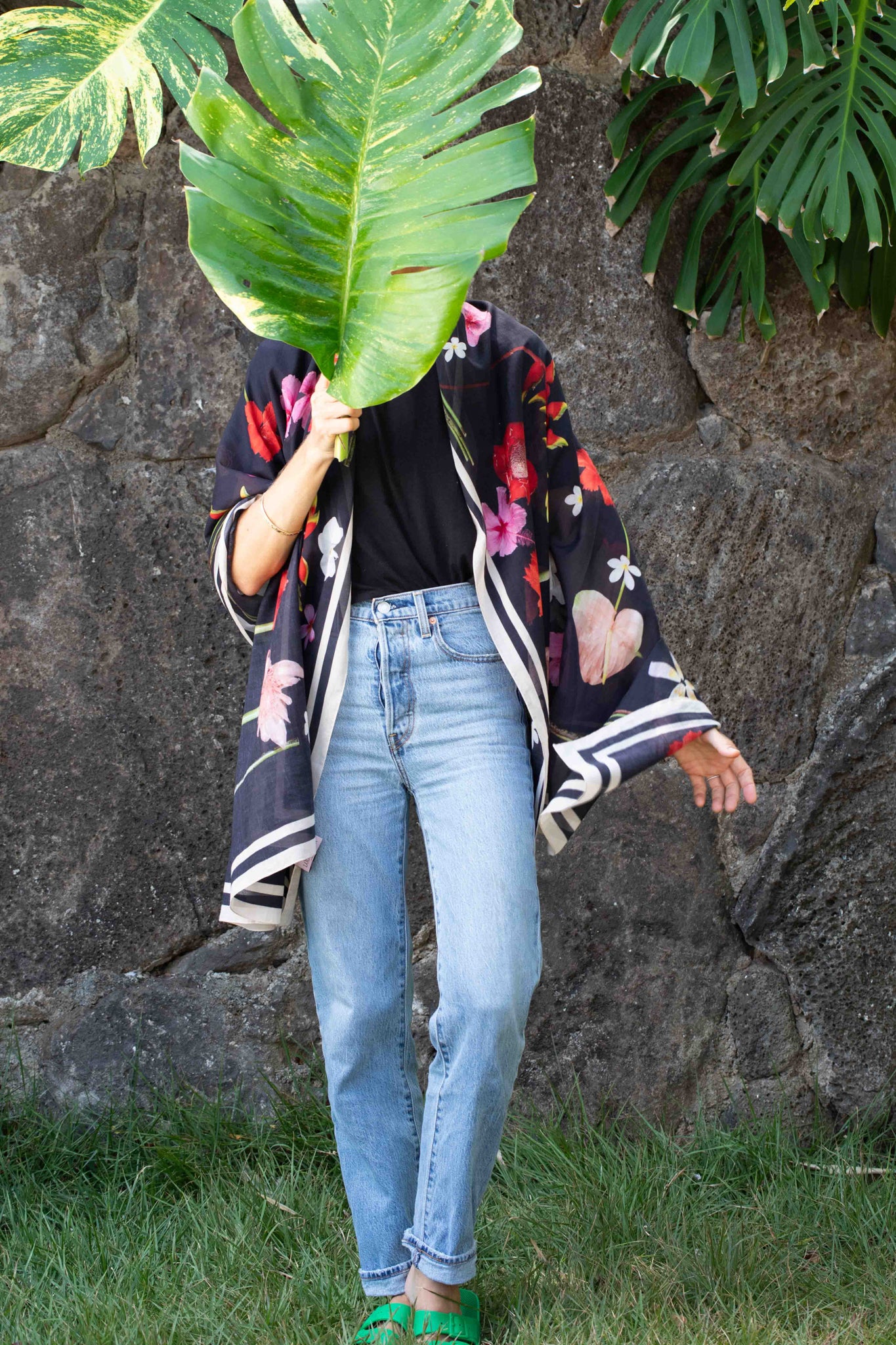Lola Pilar botanical pareo featuring tropical Hawaiian flowers on a rich black background with bold pink, yellow, red, and white accents.