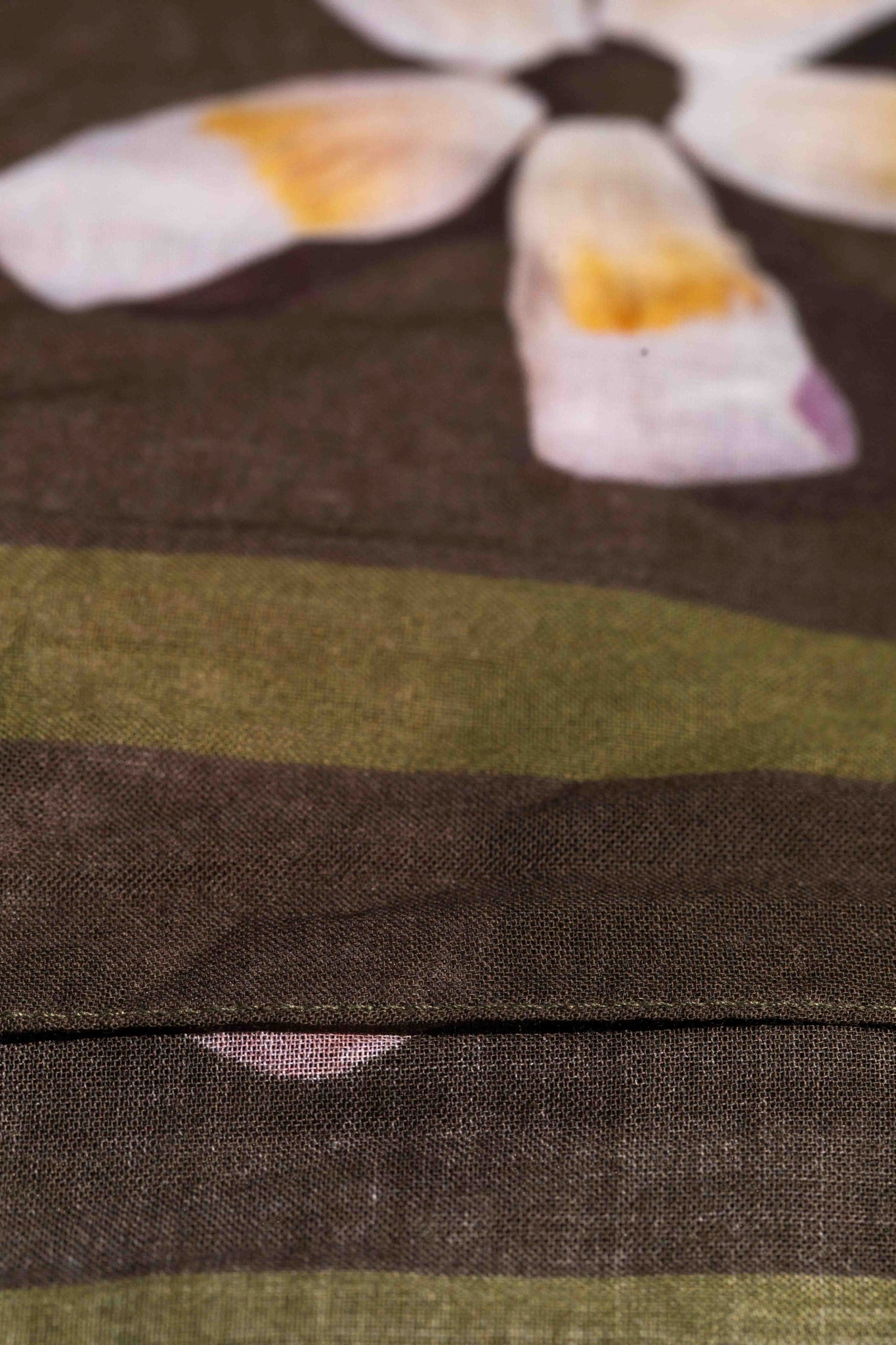 Lola Pilar botanical pareo featuring tropical Hawaiian flowers on a rich moss green background with bold pink, yellow, red, and white accents.