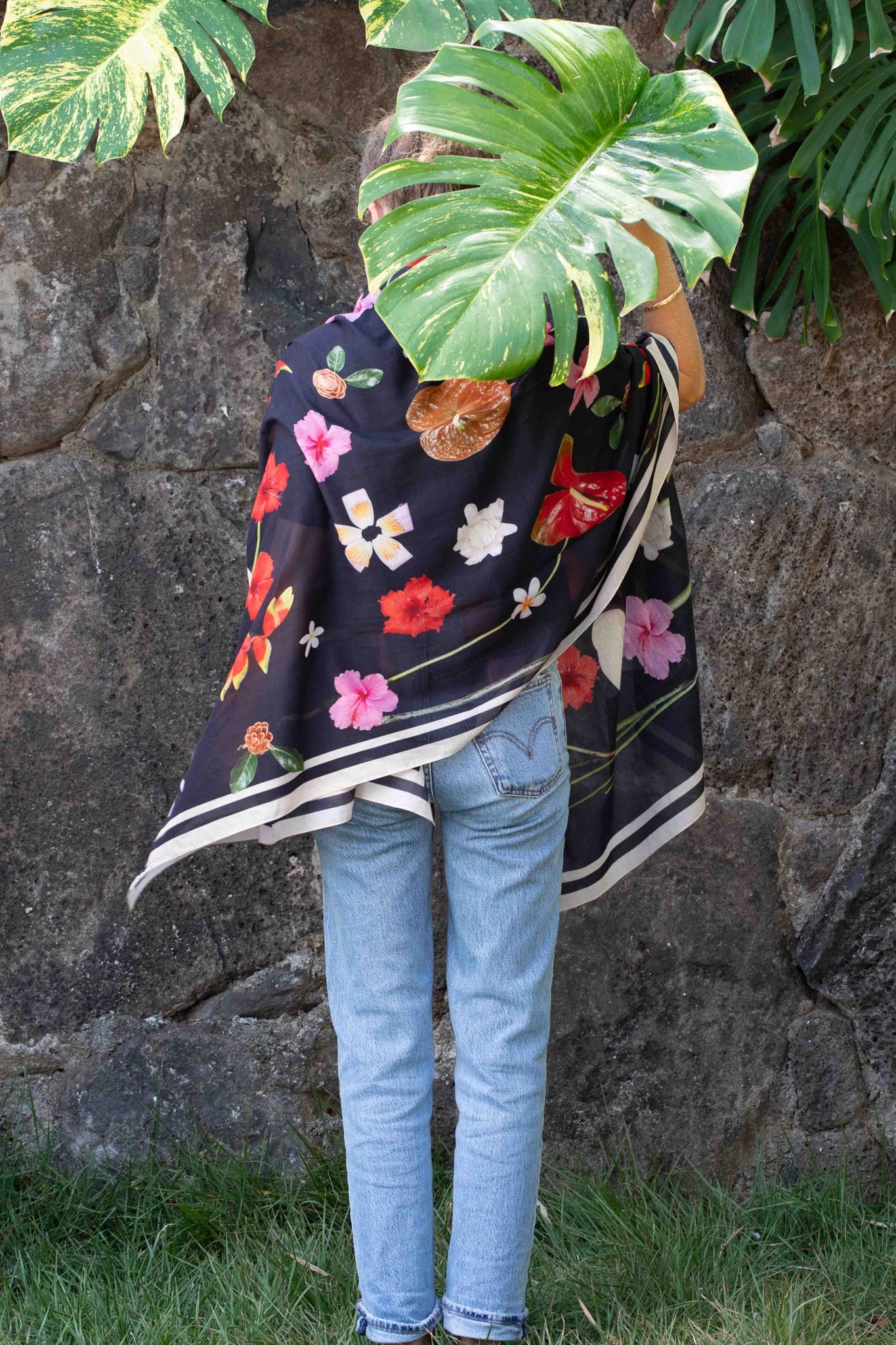 Luxury island sarong made in Italy and designed in Hawaii with colorful heliconia, hibiscus, torch ginger, plumeria, and banana flower pattern on black.