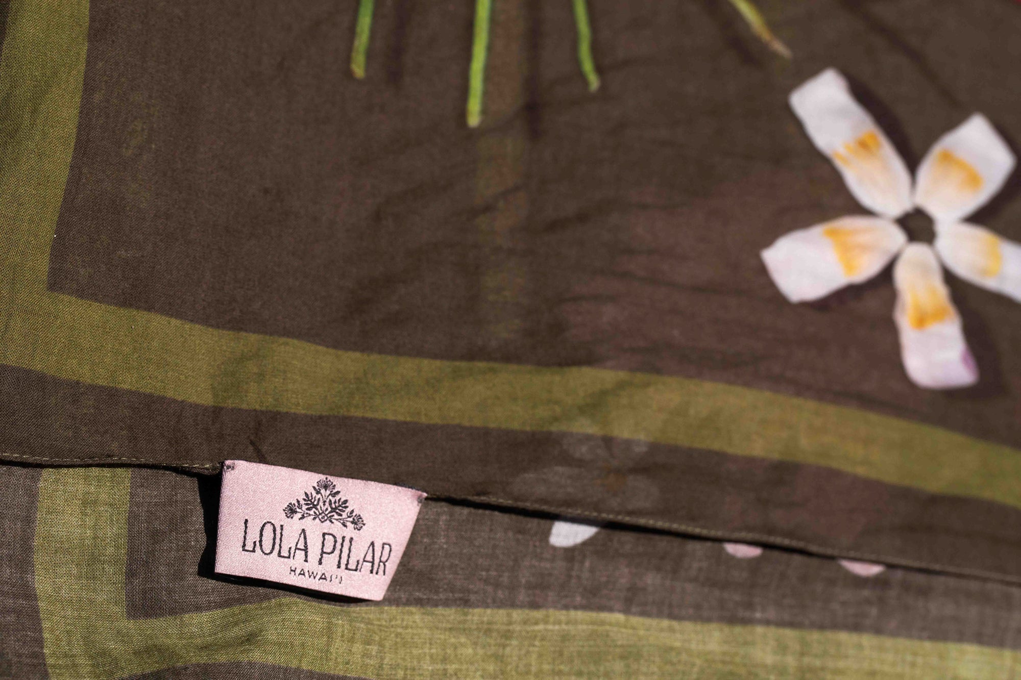 Luxury island sarong made in Italy and designed in Hawaii with colorful heliconia, hibiscus, torch ginger, plumeria, and banana flower pattern on moss green.