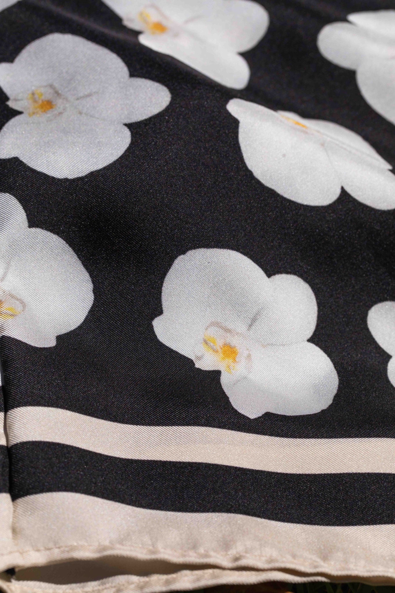 Premium black silk floral robe showcasing hibiscus, hanging heliconia, torch ginger, and plumeria in an artful Hawaii-inspired print.