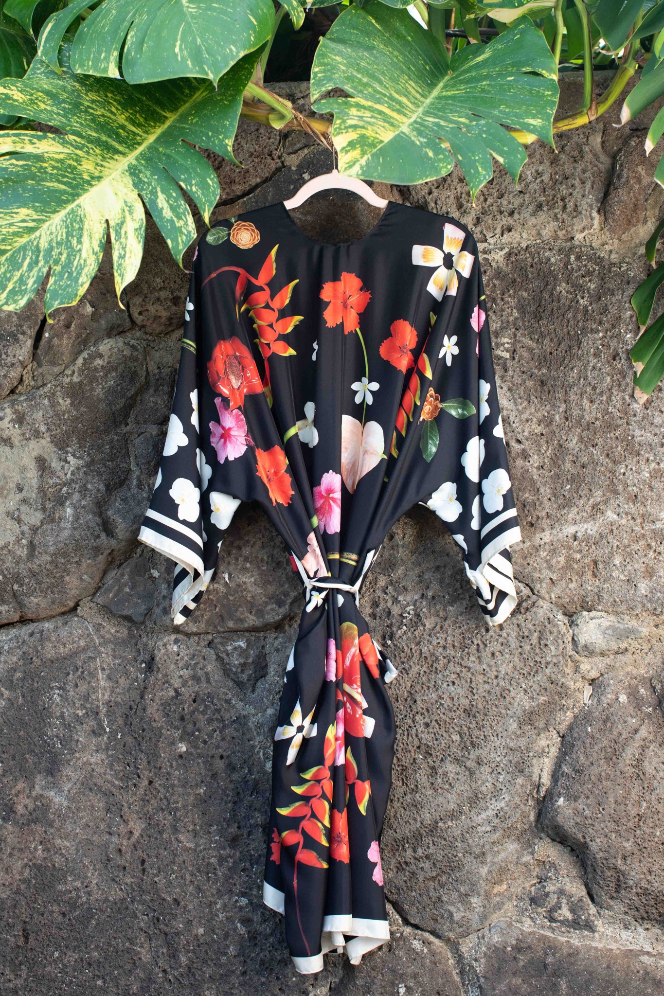 Refined silk kimono robe with bold tropical floral artwork on black silk, designed in Hawaii by Lola Pilar for chic resort evenings and luxury escapes.
