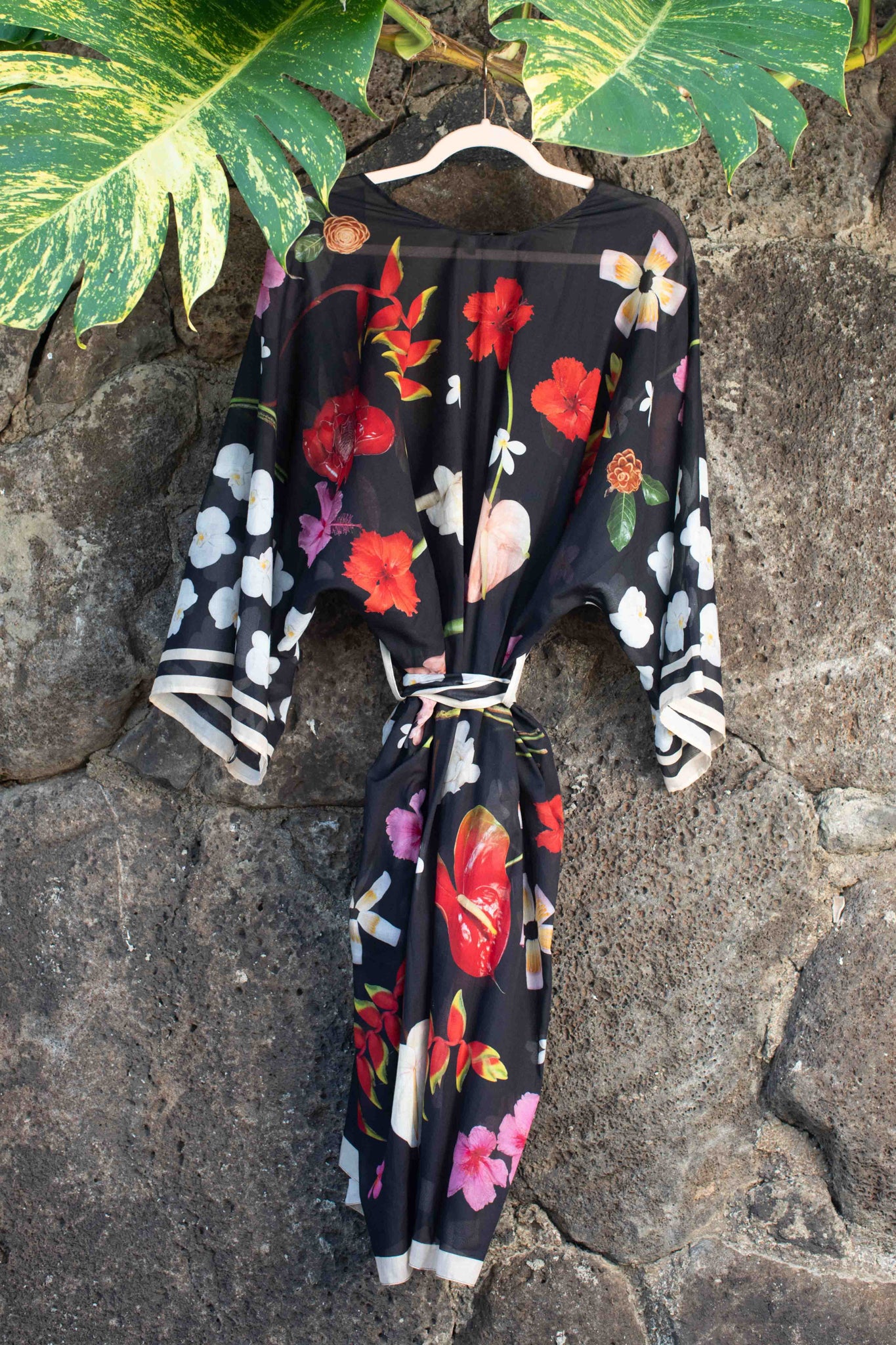 Sophisticated black cotton robe with lush tropical Hawaiian blooms in rich pink, red, yellow, and white tones, made in Italy and designed in Hawaii by Lola Pilar.
