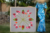 Woman in a Hawaiian mumu holding a large 4ftx4ft print called Spindly Flamingo inspired by the Hawaiian quilt