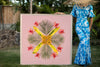 Woman in a hawaiian mumu holding a large 4ftx4ft of the Pink Palace photographic art inspired by the hawaiian quilt